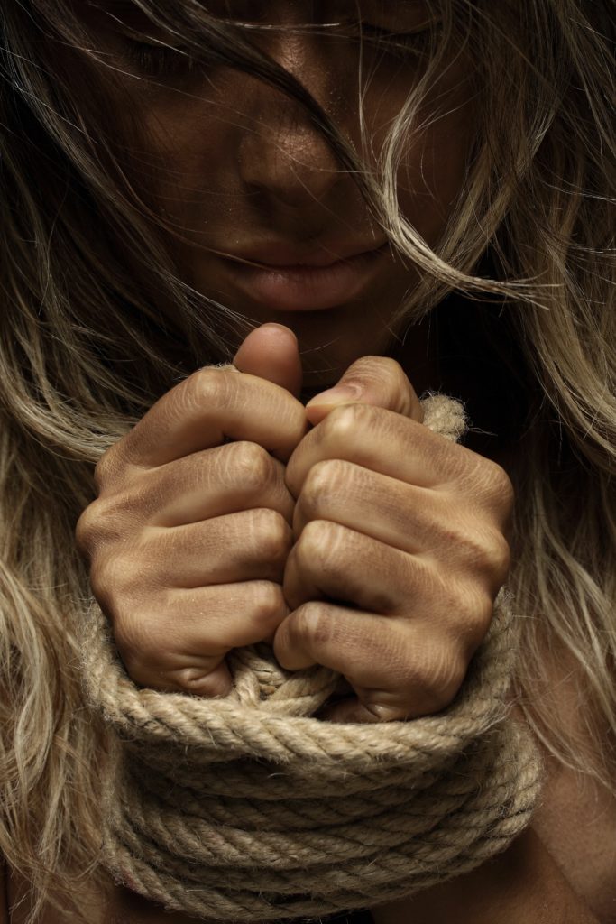 image of woman's hands bound with rope