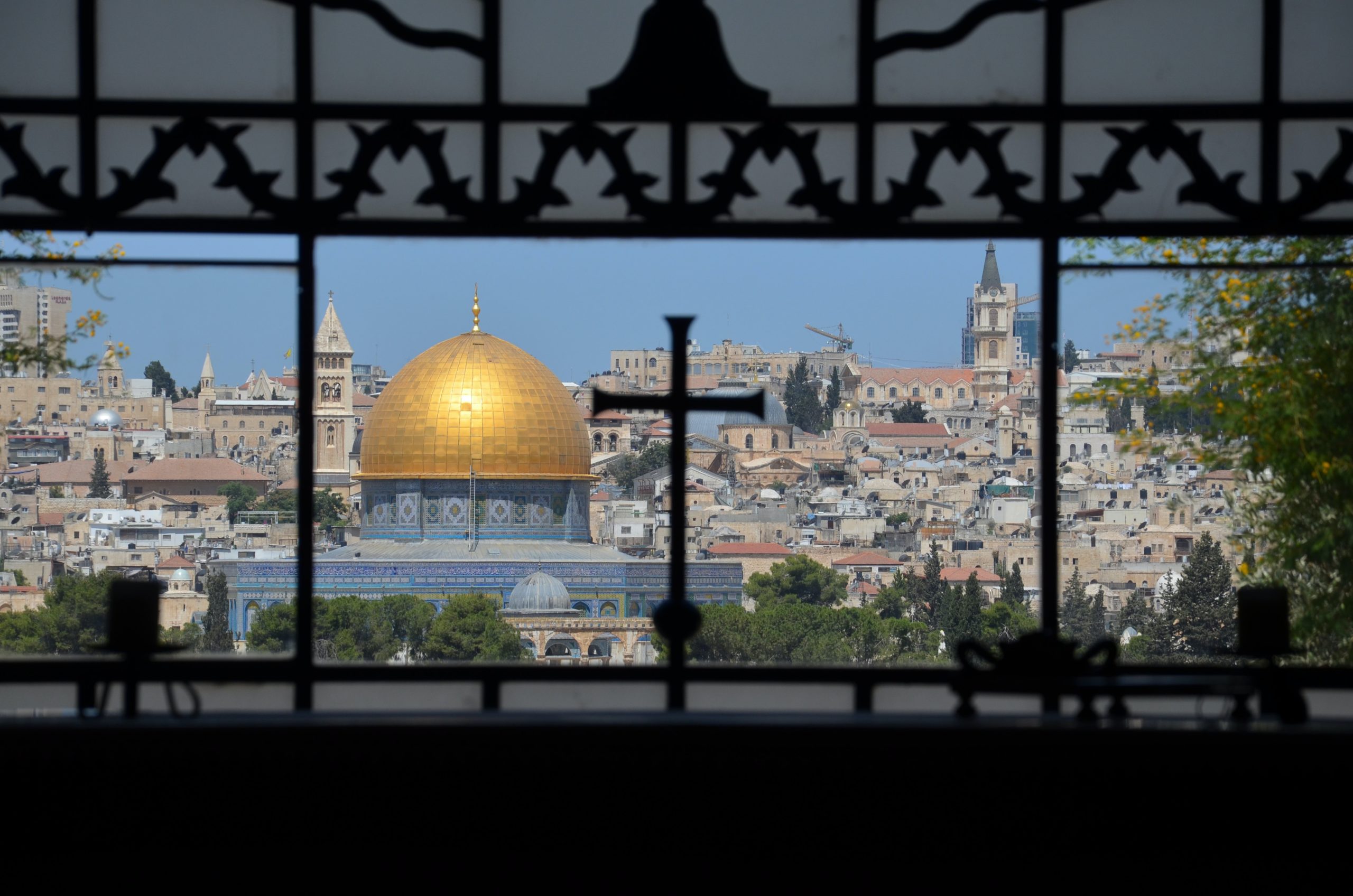 An image of a cross with a mosque in the background taken on the Dome of the Rock in Jerusalem